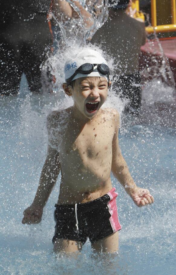 A Taiwanese boy gets a splash of water to cool down in summer heat at Taipei Water Museum in Taipei, Taiwan.