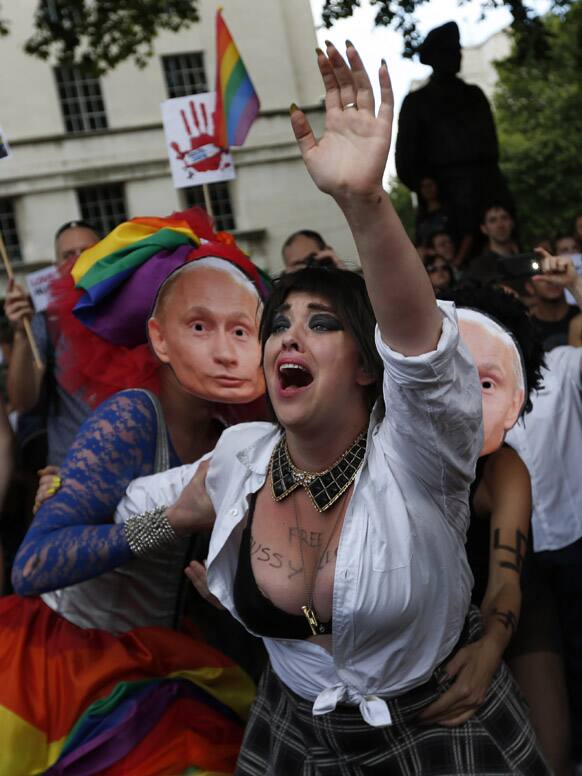 Activists stage a theatrical play where gay people are restrained by others wearing masks depicting Russian President Vladimir Putin, during a protest against Russia`s new law on gays, in central London.