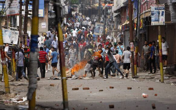 Hindu protesters throw stones at policemen during a protest after rival communities clashed in Kishtwar, in Jammu.