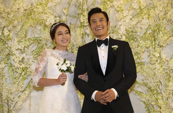 South Korean actor Lee Byung-hun, right, smiles with his bride and actress Rhee Min-jung during a press conference before their wedding in Seoul, South Korea.