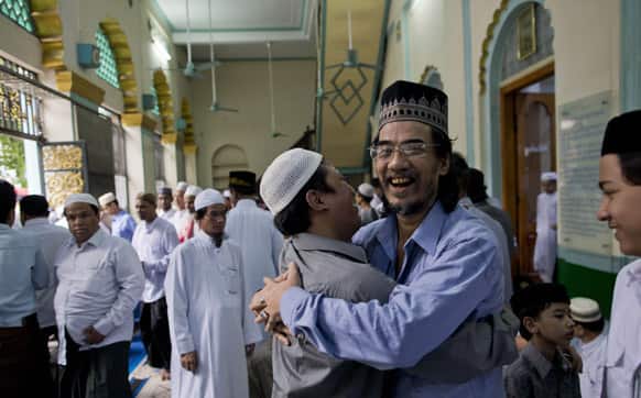 Myanmar Muslims greet each other after offering prayers during a celebration of Eid al-Fitr marking the end of holy fasting month of Ramadan in Yangon, Myanmar.