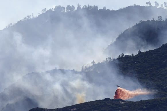 An air tanker drops fire retardant on a hot spot as firefighters continue to battle a wildfire, near Banning, Calif. Southern California firefighters are facing another day of battle as they try to corral a wildfire that has destroyed 26 homes.