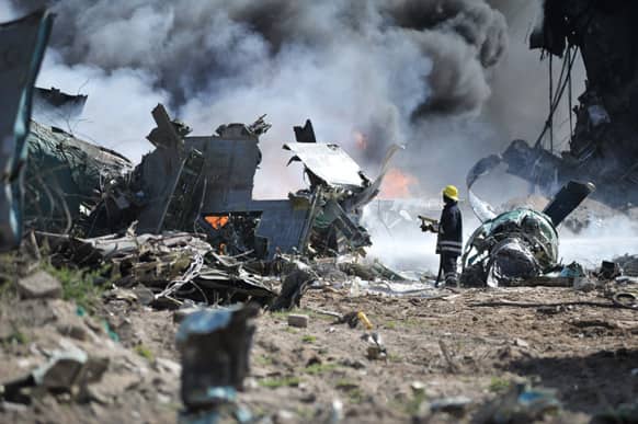An African Union Mission in Somalia (AMISOM)firefighter attempts to extinguish the fire at the site of an airplane crash in Mogadishu, Somalia. An Ethiopian Air Force aircraft crashed upon landing this morning at Mogadishu`s Aden Adde International Airport.