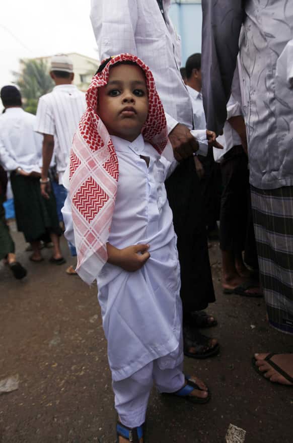 A Myanmar Muslim boy joins as Muslims gather to pray at a mosque during the festival of Eid al-Fitr on the outskirts of Yangon, Myanmar.