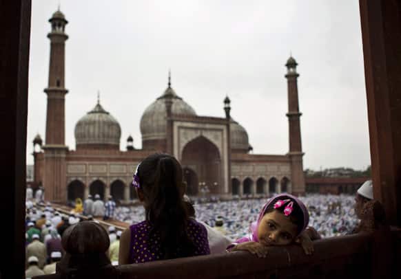 A young Muslim girl watches as others take part in Eid al-Fitr prayers at Jama Masjid in New Delhi.