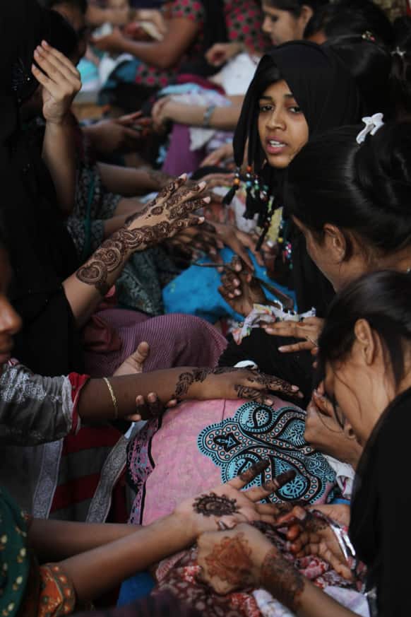 Pakistani girls get their hands painted with henna ahead of the Muslim Eid al-Fitr holiday in Karachi.