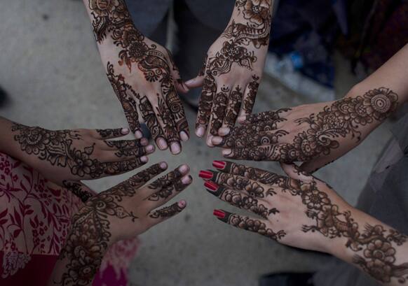 Pakistan girls show their hands painted with henna ahead of the Muslim Eid al-Fitr holiday in Karachi, Pakistan.