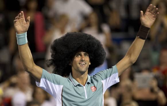 Novak Djokovic, from Serbia, wears a wig as he celebrates his victory over Denis Istomin, from Uzbekistan, at the Rogers Cup men`s tennis tournament in Montreal. Djokovic won 2-6, 6-4, 6-4.