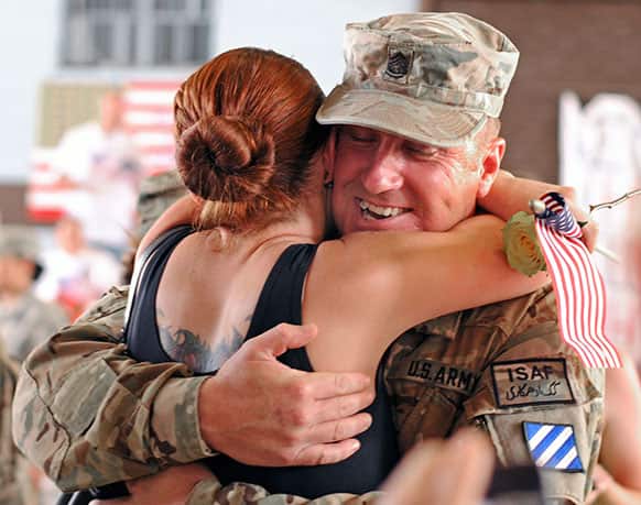 Army Sgt. 1st Class James Conway wraps his fiance Heather Woodruff at Hunter Army Airfield, Ga.