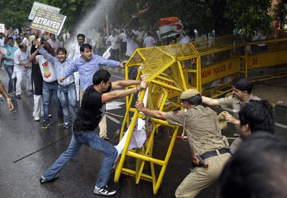 Activists of Congress party`s youth wing try to break barricades as police use water cannon to stop them during a protest against the death of five Indian army soldiers in cross-border exchanges, New Delhi.
