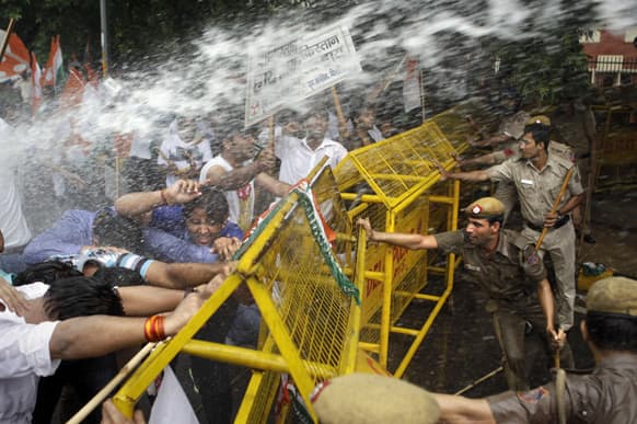 Activists of Congress party`s youth wing try to break barricades as police use water cannon to stop them during a protest against the death of five Indian army soldiers in cross-border exchanges, New Delhi.