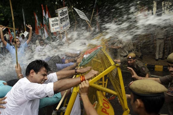 Activists of Congress party`s youth wing try to break barricades as police use water cannon to stop them during a protest against the death of five Indian army soldiers in cross-border exchanges, New Delhi.