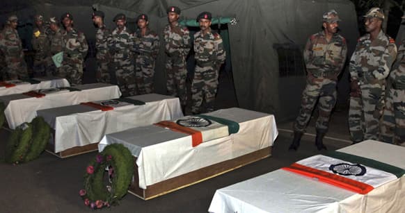 Indian army soldiers stand near the coffins of Indian soldiers allegedly killed by Pakistani soldiers during a wreath laying ceremony at Poonch, some 200 kilometers (125 miles) from Jammu.