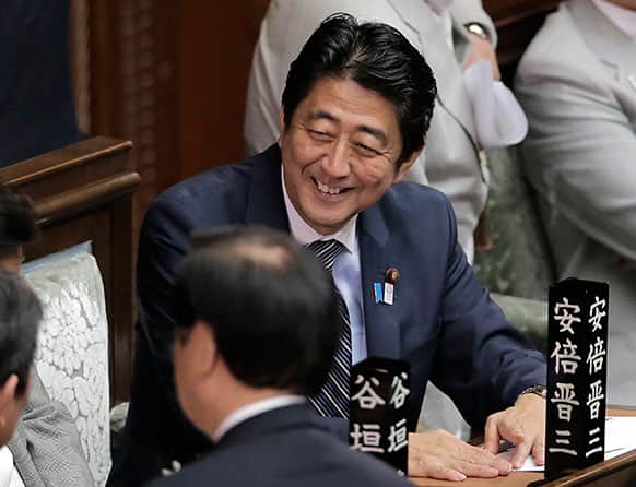 Japanese Prime Minister Shinzo Abe smiles at the lower house of Parliament extraordinary session in Tokyo.