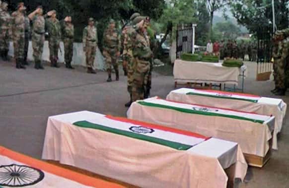 Indian army soldiers salute as they pay tribute to their colleagues at a wreath laying ceremony in Poonch.