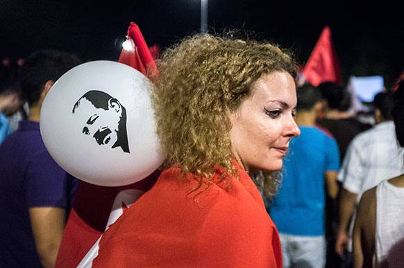 A woman carries a balloon with a portrait of slain Tunisian lawyer and politician Chokri Belaid, during a demonstration against Tunisia`s Islamist-led government in Tunis.