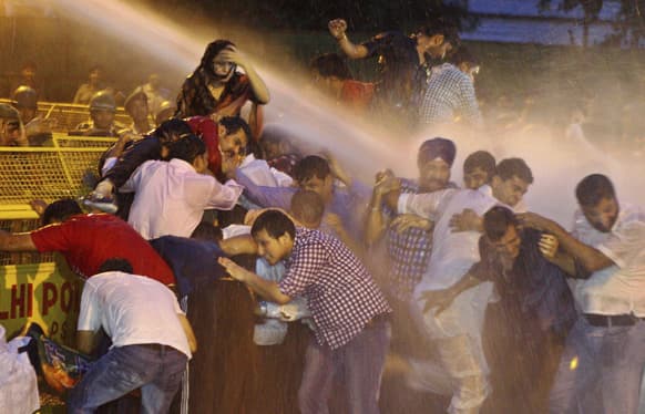 Activists of youth wing of Bharatiya Janata Party (BJP) are drenched by water cannon jets by police during a protest against the death of five Indian army soldiers in cross-border exchanges, in New Delhi.