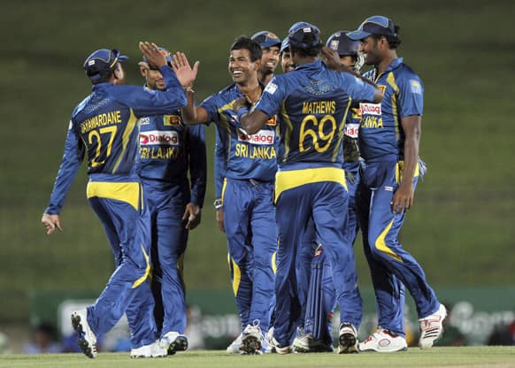 Members of the Sri Lankan team congratulate their bowler Nuwan Kulasekara for taking the wicket of South Africa`s Henry Davids during their third Twenty20 cricket match in Sooriyawewa, Sri Lanka.