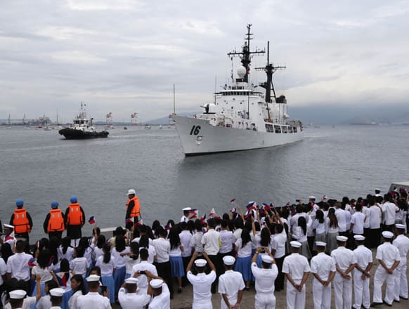 Students and other guests wave Philippine flags to welcome the second warship of the Philippine Navy, the BRP Ramon Alcaraz at Subic Freeport, about 80 kilometers (50 miles) northwest of Manila, Philippines.