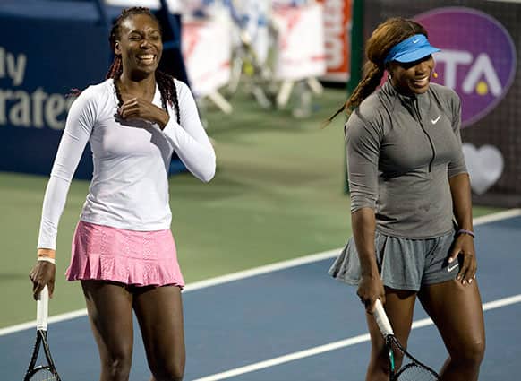 Venus Williams and Serena Williams laugh during an exhibition doubles match during Rogers Cup women`s tennis action in Toronto.