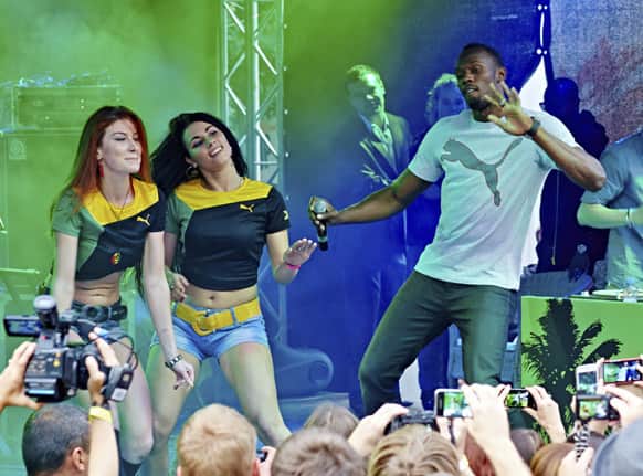 Usain Bolt of Jamaica, right, entertains fans during the PUMA Jamaica Party after his arrival in Moscow at Puma Social Club in the Gorky Park.