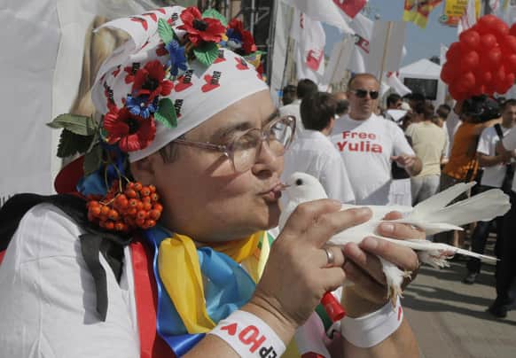 A supporter of former Ukrainian Prime Minister Yulia Tymoshenko kisses a white bird as a symbol of protest during a rally in a tent camp in central Kiev, Ukraine.