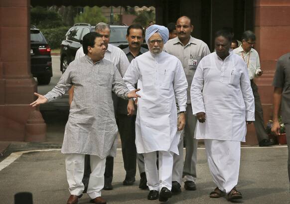 Prime Minister Manmohan Singh, talks to his cabinet members as they walk towards media after his arrival at the opening day of the monsoon session of the parliament, in New Delhi.