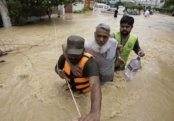 Pakistani soldiers rescue a resident from an area flooded by heavy rains on the outskirts of Karachi, Pakistan.