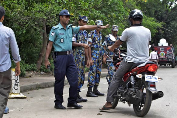 Bangladeshi police stop a motorist for checking in front of the US embassy building that remained closed due to security threat in Dhaka.