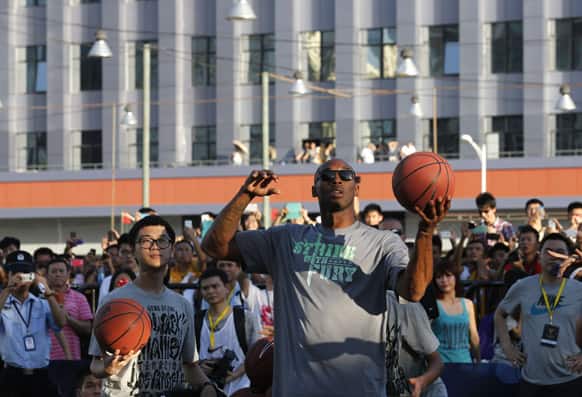 NBA star Kobe Bryant throws a ball during a meeting with fans in China`s southern city of Shenzhen.