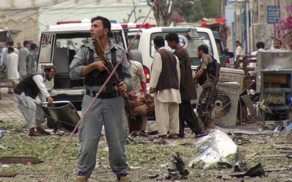 Security officials conduct investigation at the scene of suicide bomb attacks in Jalalabad. Three suicide attackers killed at least nine civilians, most of them children, in a botched attack Saturday on the Indian consulate in an eastern Afghan city near the border with Pakistan, security officials said.