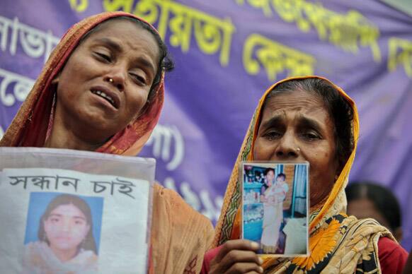 Bangladeshi mothers cry for their missing ones while holding their photos at the site of the collapsed Rana Plaza building in Savar near Dhaka, Bangladesh.