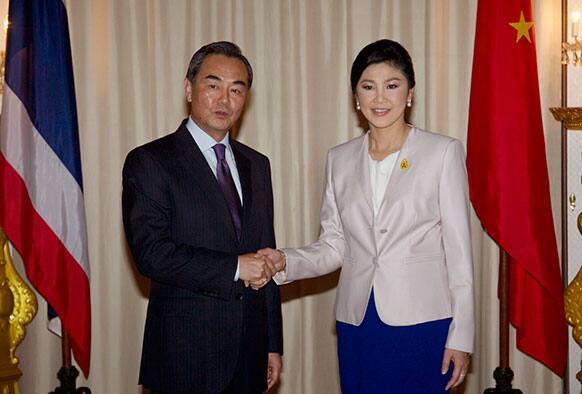 Chinese Foreign Minister Wang Yi shakes hands with Thai Prime Minister Yingluck Shinawatra at Government House in Bangkok.