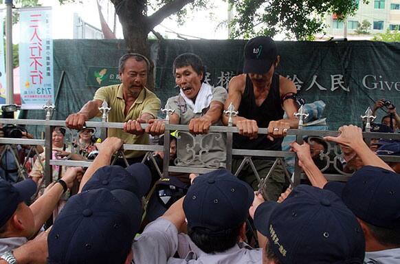 Anti-nuclear protesters face off police as they try to pull down the gate of the legislature in Taipei, Taiwan.