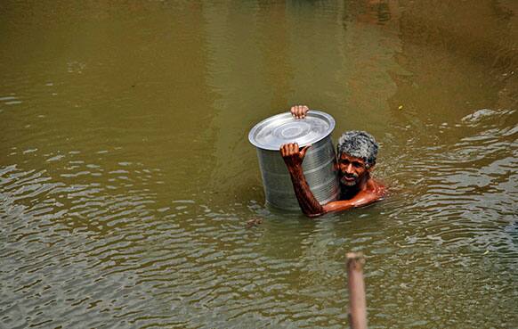 A flood affected victim of a low lying residential area tries to reach to a safer ground after the overflowing of the Ganges River after heavy monsoon rains in Allahabad, India.