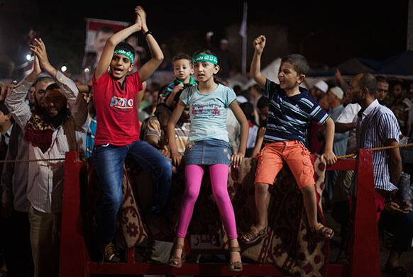 Egyptian children wear head bands with Arabic writing reads: