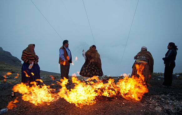 A family sets a bonfire with offerings to the