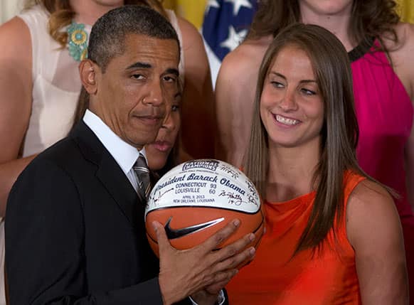 University of Connecticut Huskies basketball guard Caroline Doty looks at President Barack Obama as he shows the signed basketball she just gave him during a ceremony in the East Room of the White House in Washington.
