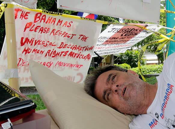 Ramon Saul Sanchez, president of the Democracy Movement, talks to a reporter as he lies in a bed during his hunger strike to protest the alleged abuse of about 40 Cubans who are detained in the Bahamas in Miami.