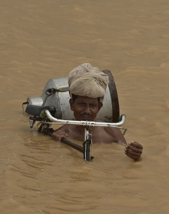 A villager with his bicycle wades through flood waters at Maner block in Patna district in Bihar.