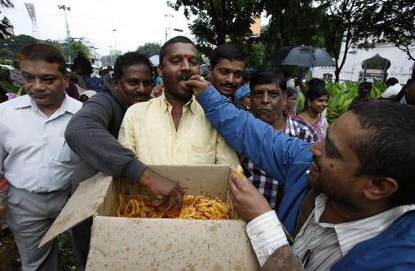 People celebrate by distributing sweets after India`s ruling coalition endorsed creating a new state in southern India, in Hyderabad.