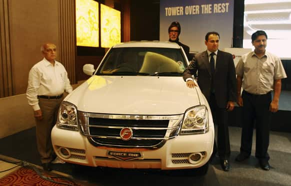 President of corporate sales & marketing of Force Motors Limited NK Rattan, left, Managing Director of Force Motors Limited Prasan Firodia second from left, and principal dealer Ramesh Puri pose for a photo during the launch of the SX variant of the Force One SUV in New Delhi.