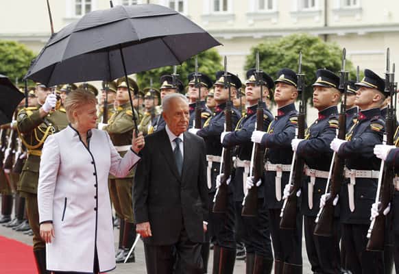 Israel`s President Shimon Peres, right, with Lithuania`s President Dalia Grybauskaite reviews a guard of honor during a welcome ceremony at the presidential palace in Vilnius.