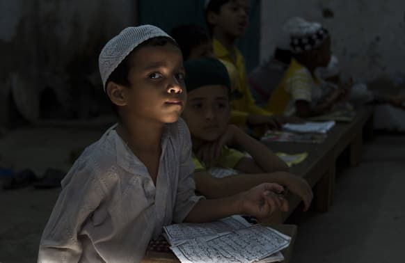 Muslim children take lessons on the Quran at a Madrasa or Muslim religious school, during Ramadan in New Delhi.