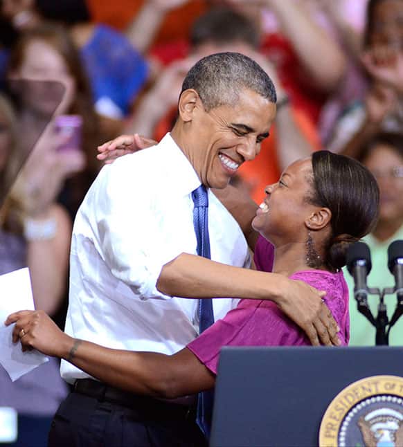 President Barack Obama hugs Amazon employee Lydia Flanders after she introduced him, at the Amazon fulfillment center in Chattanooga, Tenn.