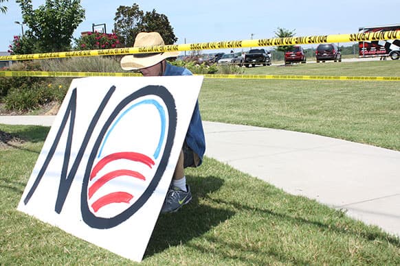 An unidentified protester holds a sign on Lee Highway during President Barack Obama`s visit to Chattanooga, Tenn.