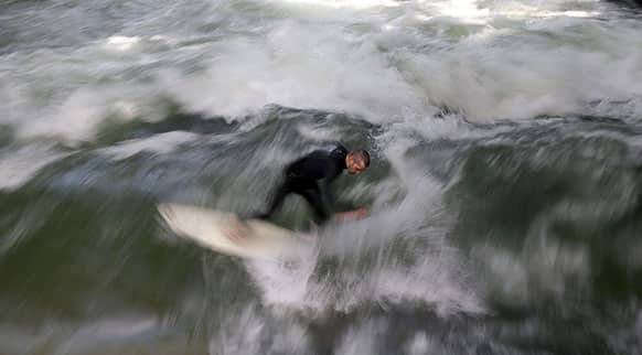 A surfer rides on a wave in the river Eisbach in the English Garden in downtown Munich, southern Germany.