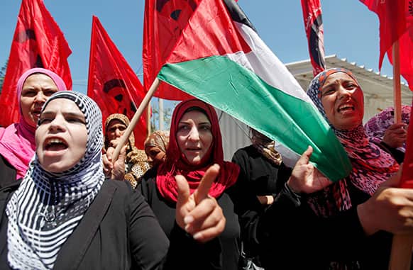 Palestinian women chant slogans and wave Palestinian and red flags, that represent the Palestinian Marxist-Leninist secular political and military organization, during a demonstration organized by the Democratic Front for the Liberation of Palestine, against resuming peace talks with Israel in Gaza City.