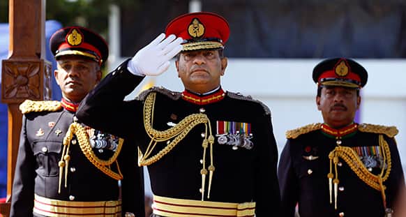 Sri Lankan army commander Lt. Gen. Jagath Jayasuriya, center, salutes as the next Army Commander Major Gen. Daya Ratnayake, left, and Major Gen. Jagath Dias watch a military parade in Colombo, Sri Lanka.
