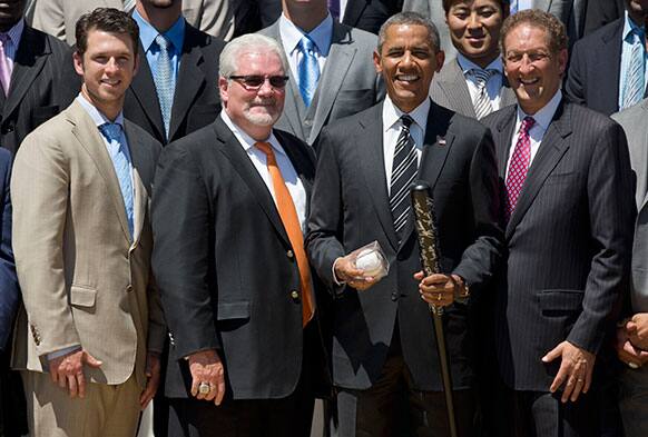 President Barack Obama holds an a autographed bat and ball during a ceremony on the South Lawn of the White House in Washington.